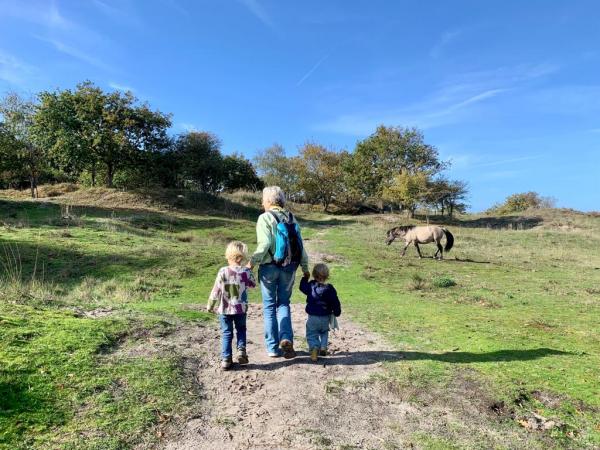 Oma loopt met twee kleinkinderen door Oranjezon